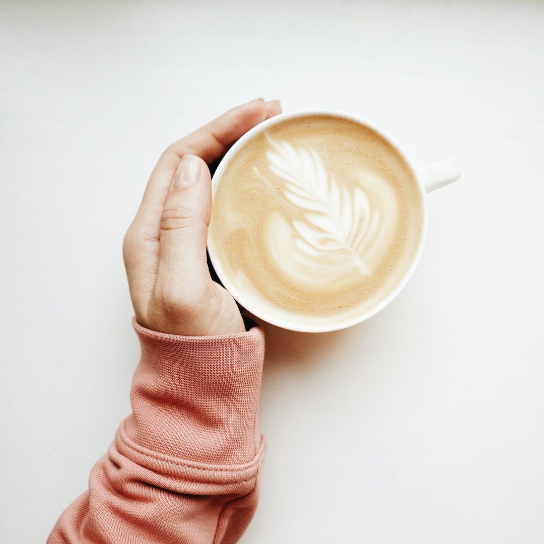 person holding white mug